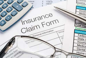Insurance Claim Form with pen and calculator