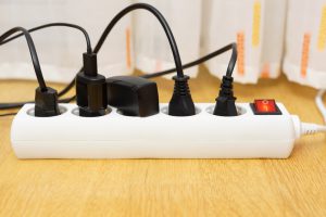 many electrical appliances pluged in surge protector. Power consuption concept